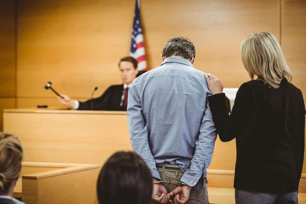 Man with head down before a judge